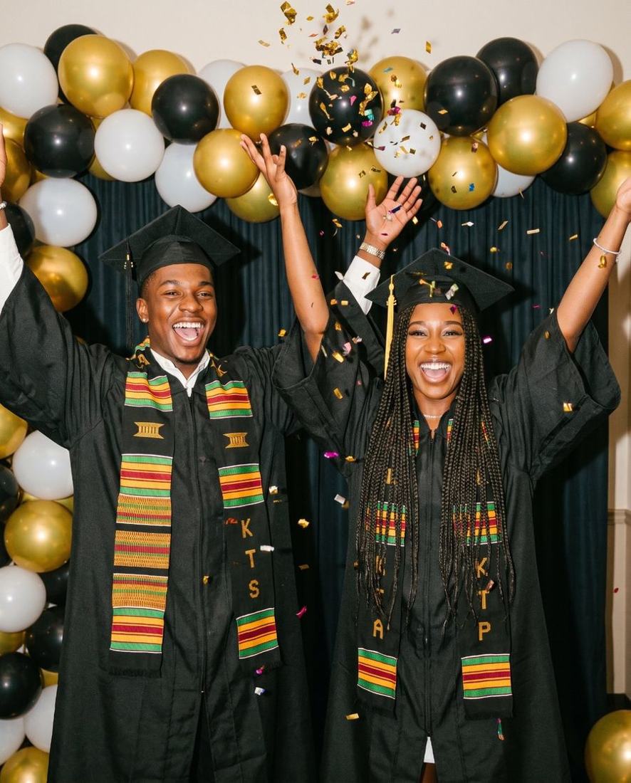 Graduates in caps and gowns throwing confetti