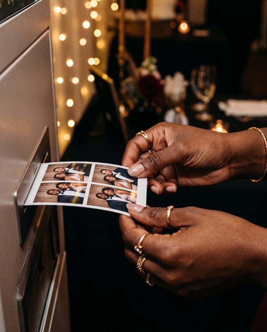 A guest holding a freshly printed photo strip